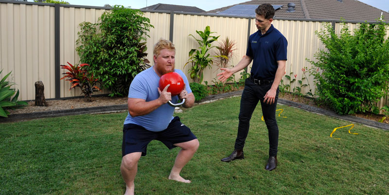 Physiotherapist helping a client with a supported exercise
